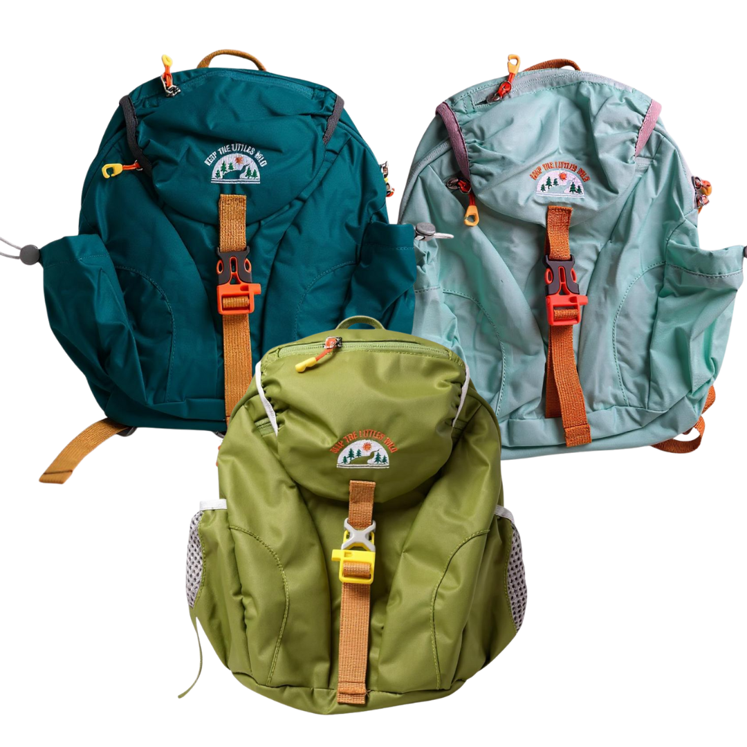 The Hiking Backpack for toddlers & kids comes in teal, light blue, and olive green with brown straps, front pockets, and outdoor-themed patches with orange accents—perfect for hiking adventures—shown together on a white background.